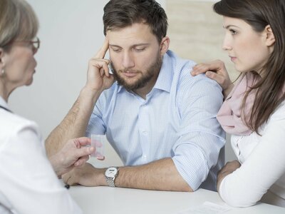 couple discussing fertility with an rei specialist at their first infertility workup