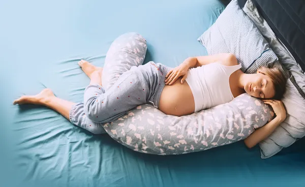 How To Sleep With a Pregnancy Pillow + Our 4 Faves - Rescripted